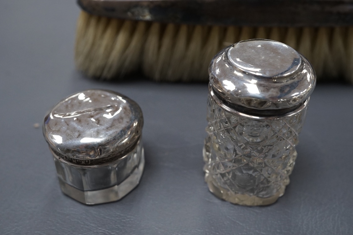 A George V oval silver trinket box, Adie Bros. Birmingham, 1922, 10.8cm, together with a silver compact, four assorted silver mounted toilet jars and a silver mounted hair brush.